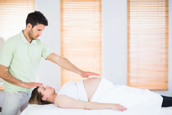 Mulher grávida relaxada recebendo tratamento reiki — Fotografia de Stock