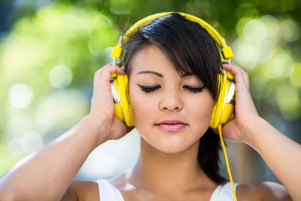 Mujer con auriculares amarillos — Foto de Stock