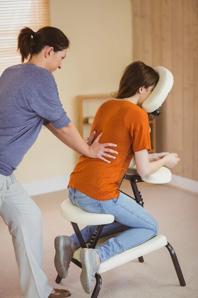 Jeune femme se faire masser dans la chaise — Photo