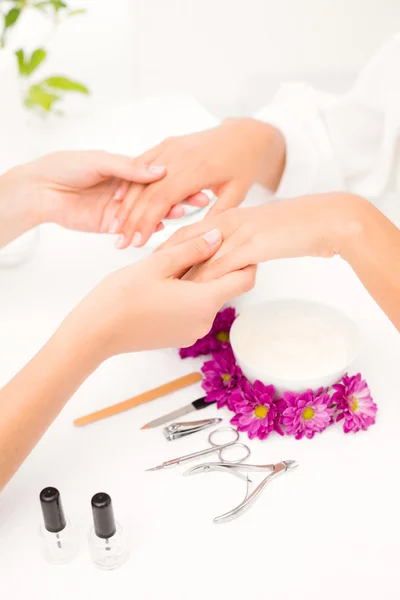 Beautician filing female client's nails — Stock Photo, Image