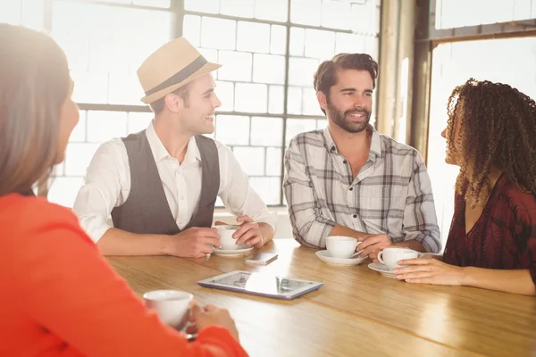 Smiling friends talking and having coffee together — Stock Photo, Image