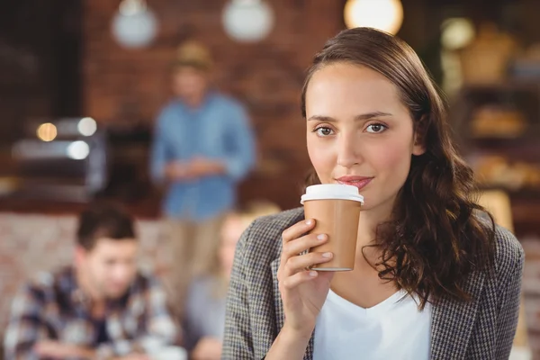 Lächelnde junge Frau trinkt aus Take-away-Becher — Stockfoto
