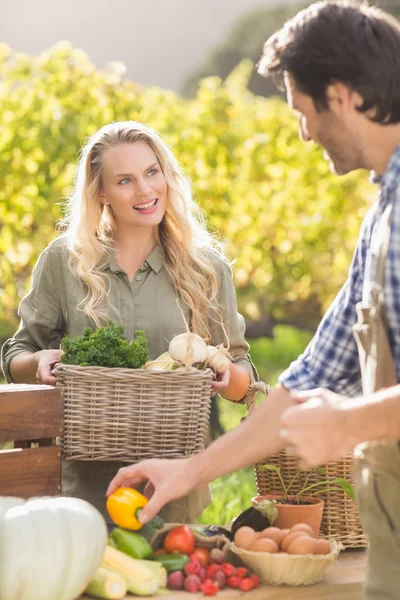 Smiling blonde customer buying vegetables — Stock Photo, Image
