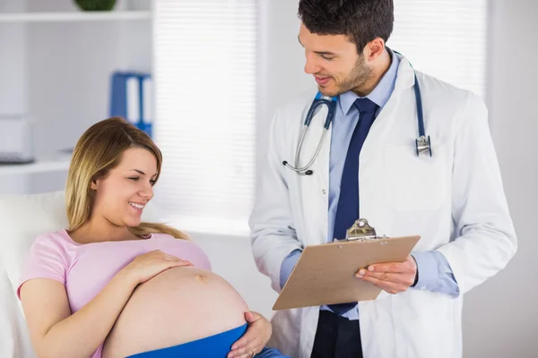 Arzt berät schwangere Patientin — Stockfoto
