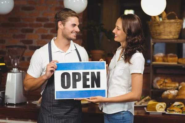 Glimlachend team poseren met open teken — Stockfoto