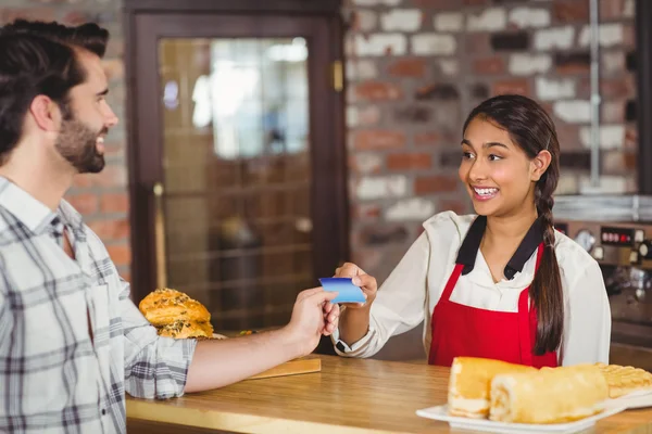 Client remettant une carte de crédit à la serveuse — Photo