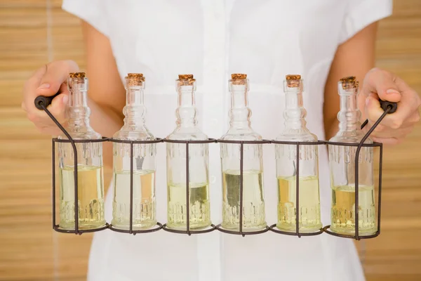 Mujer sosteniendo botellas de masaje de aceite —  Fotos de Stock