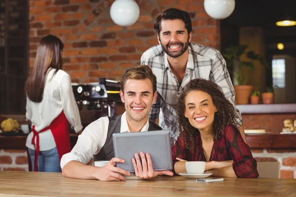 Smiling friends holding a digital tablet — Stock Photo, Image