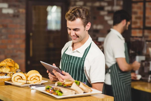 Smiling waiter using a digital tablet — Stock Photo, Image