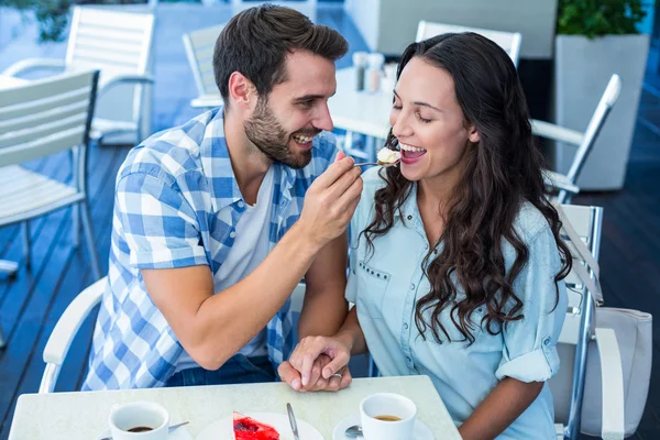 Unga lyckliga paret mata varandra med tårta — Stockfoto