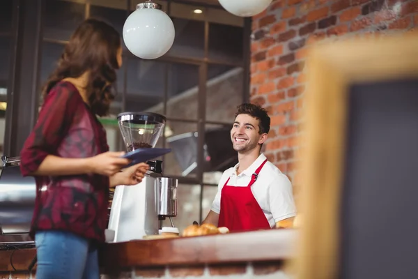 Knappe barista bespreking met een klant — Stockfoto