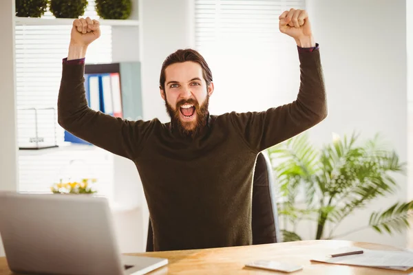 Hipster businessman cheering at his desk — Stok fotoğraf