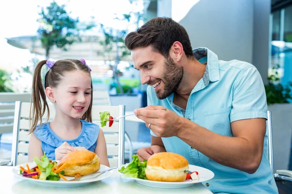 Daughter and father eating at the restaurant — Stock Photo, Image