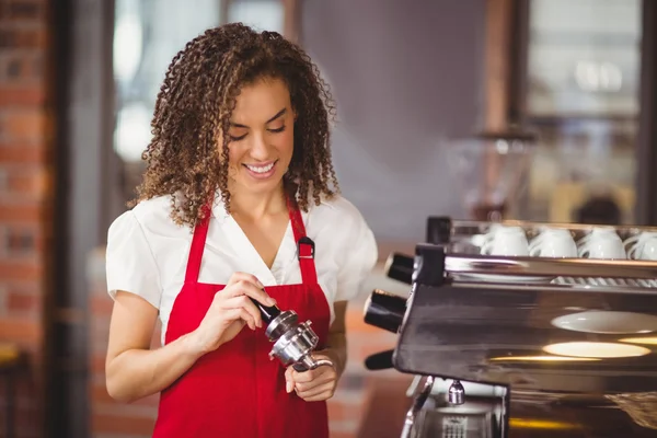 Um barista sorridente pressionando café — Fotografia de Stock