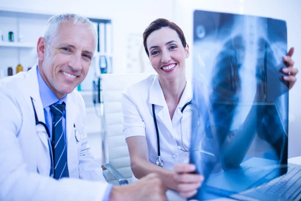 Colegas médicos sonrientes sosteniendo rayos X — Foto de Stock