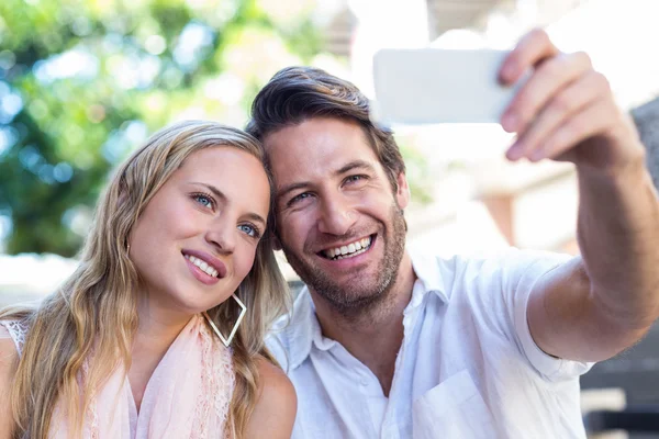 Paar sitzt und macht Selfies — Stockfoto