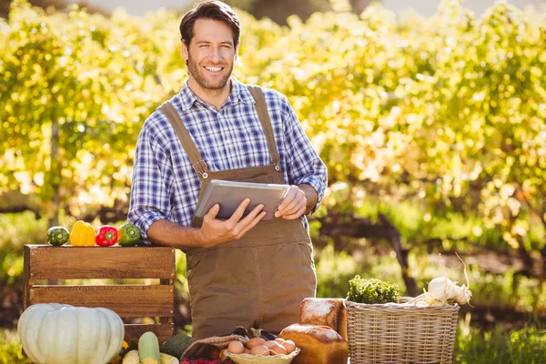 Lachende landbouwproducent met gebruikmaking van een digitale tablet — Stockfoto