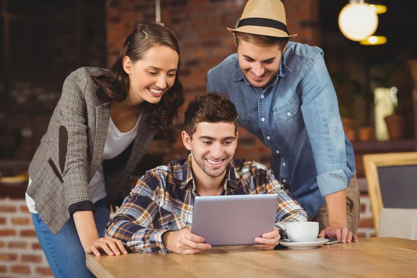 Smiling friends looking at tablet computer