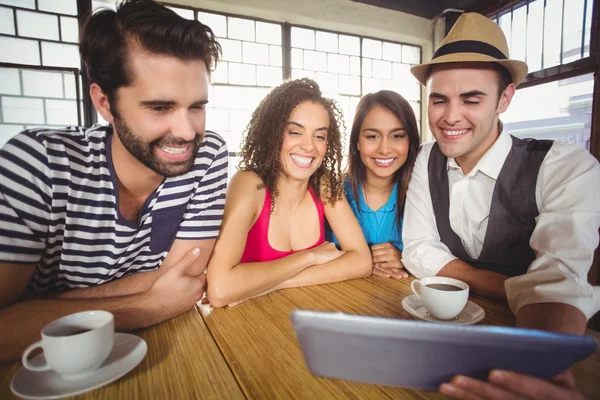 Lachende vrienden kijken naar tablet pc — Stockfoto