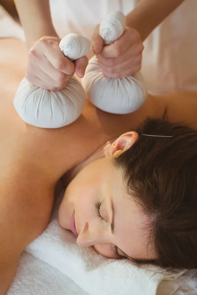 Mulher recebendo massagem de compressa de ervas — Fotografia de Stock