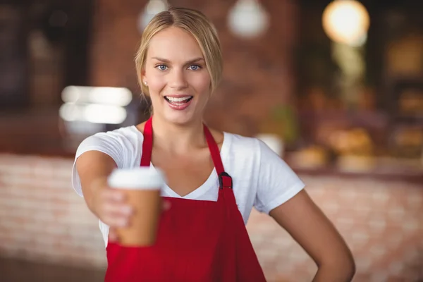 Красивая официантка протягивает кружку кофе — стоковое фото