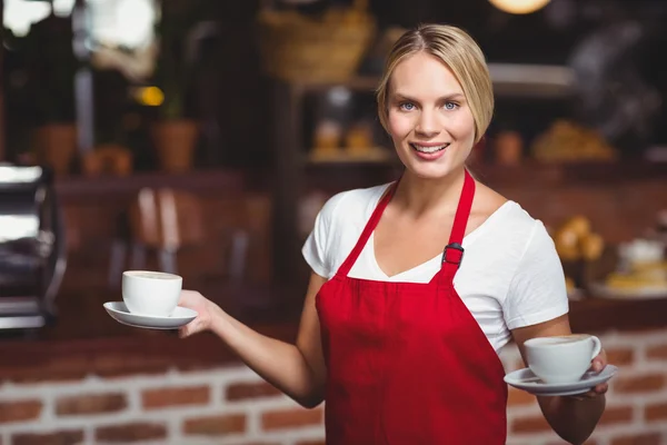 Garçonete bonita segurando duas xícaras de cafés — Fotografia de Stock