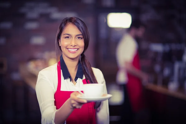 Lächelnde Kellnerin reicht eine Tasse Kaffee — Stockfoto