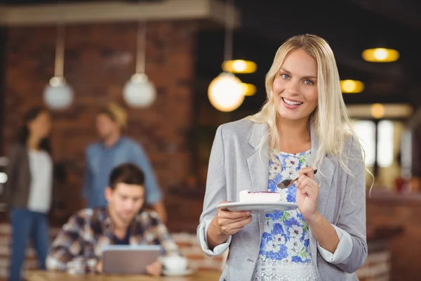 Sorridente donna bionda mangiare torta — Foto Stock