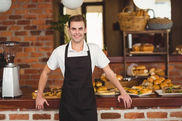 Barista sonriente de pie frente al mostrador — Foto de Stock