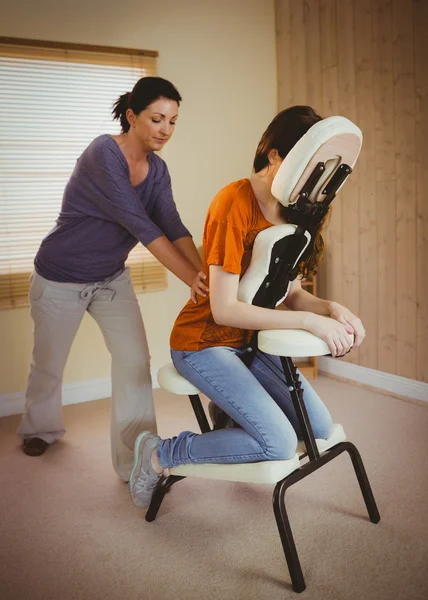 年轻女子坐在椅子上得到按摩 — 图库照片