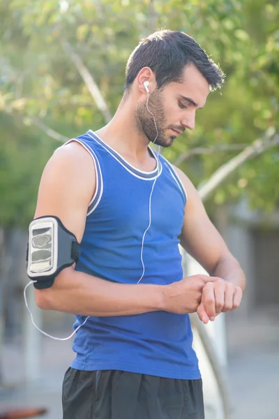 Un bell'atleta che guarda il polso. — Foto Stock