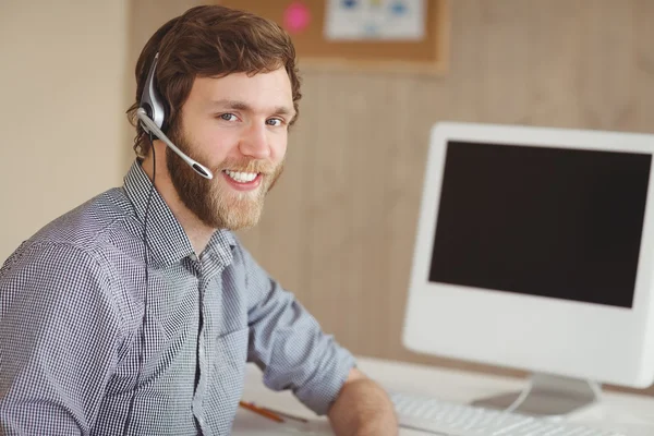 Skäggiga hipster på skrivbord med headset — Stockfoto