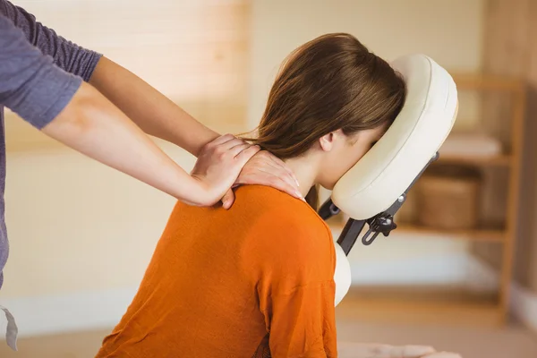 Young woman getting massage in chair — Stock Photo, Image