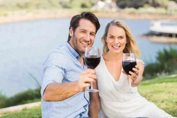 Casal bonito na data entregando copos de vinho tinto — Fotografia de Stock