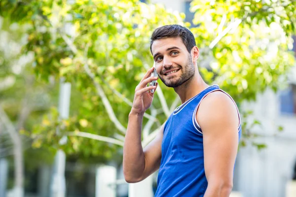 Een gelukkig knappe atleet bellen — Stockfoto