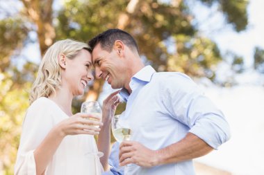 Smiling couple holding wine clipart