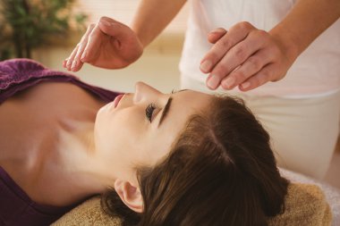 Young woman having a reiki treatment clipart