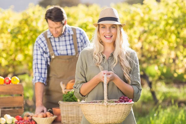 Blonde klant houden een groenten mand — Stockfoto