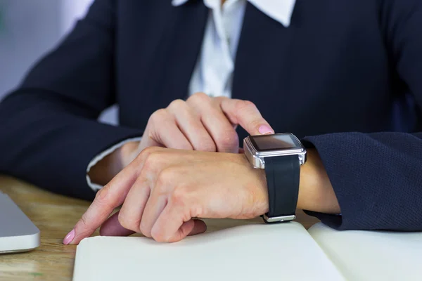 Kobieta za pomocą pokładzie smartwatch na biurko — Zdjęcie stockowe