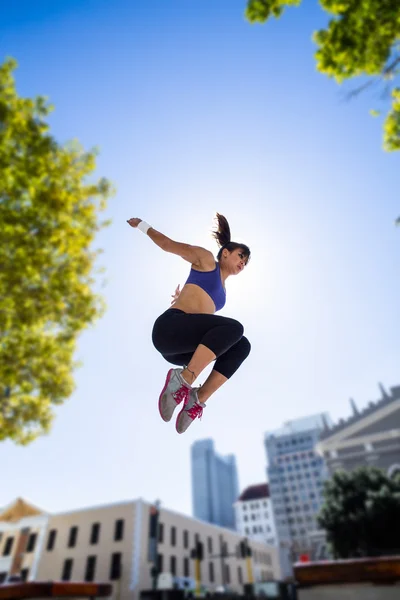 Athletische Frau springt in die Luft — Stockfoto