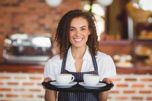 Barista sonriente sosteniendo una bandeja de tazas de café —  Fotos de Stock