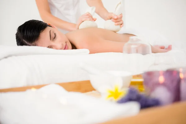 Woman enjoying herbal compress massage — Stock Photo, Image
