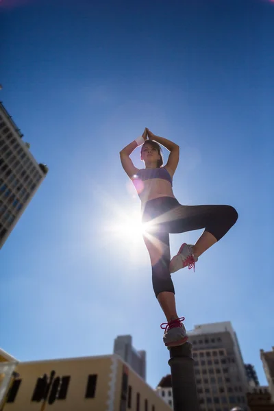 Donna atletica che fa yoga sul dissuasore — Foto Stock