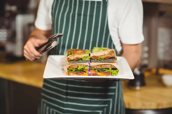 Camarero sosteniendo un plato de sándwiches — Foto de Stock