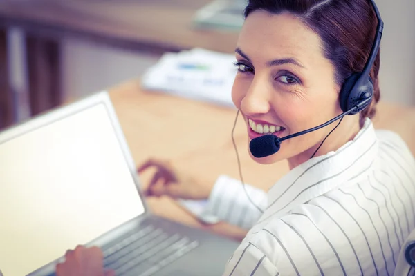 Mujer de negocios sonriendo con el ordenador portátil y auriculares —  Fotos de Stock