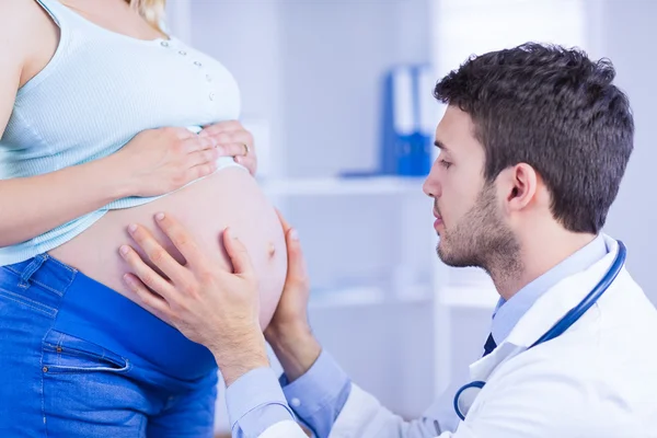 Arzt überprüft Magen einer schwangeren Patientin — Stockfoto