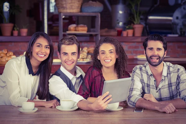 Amici sorridenti in possesso di un tablet digitale — Foto Stock