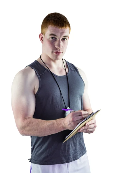 Fit personal trainer writing on clipboard — Stock Photo, Image