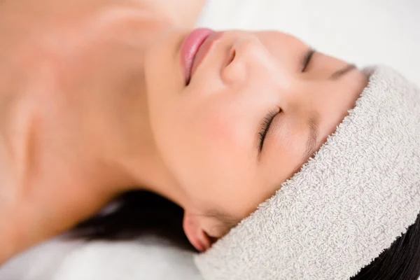 Mulher relaxada deitada na mesa de massagem — Fotografia de Stock