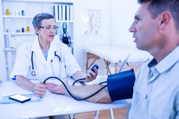 Médico control de la presión arterial del paciente — Foto de Stock